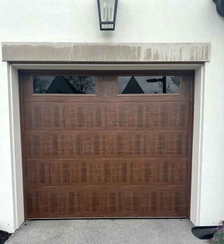 Wood-look residential garage door with upper glass panels