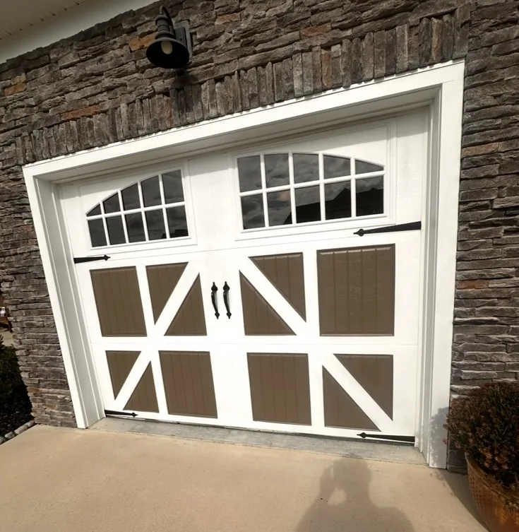 White and brown carriage style residential garage door with arched windows