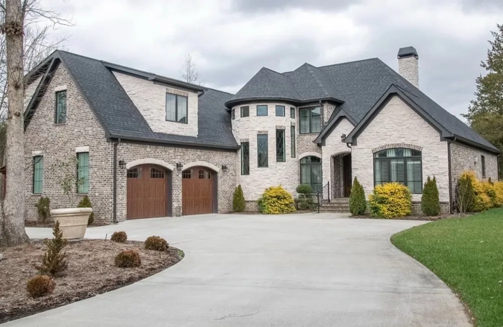 Large home with arched wood carriage style garage doors